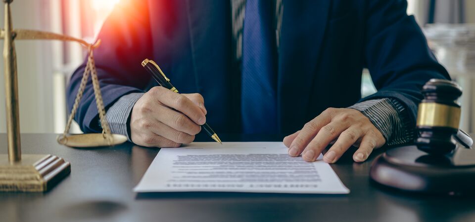 COLOUR-IMAGE_man-signing-papers-with-gavel-next-to-him_feb26