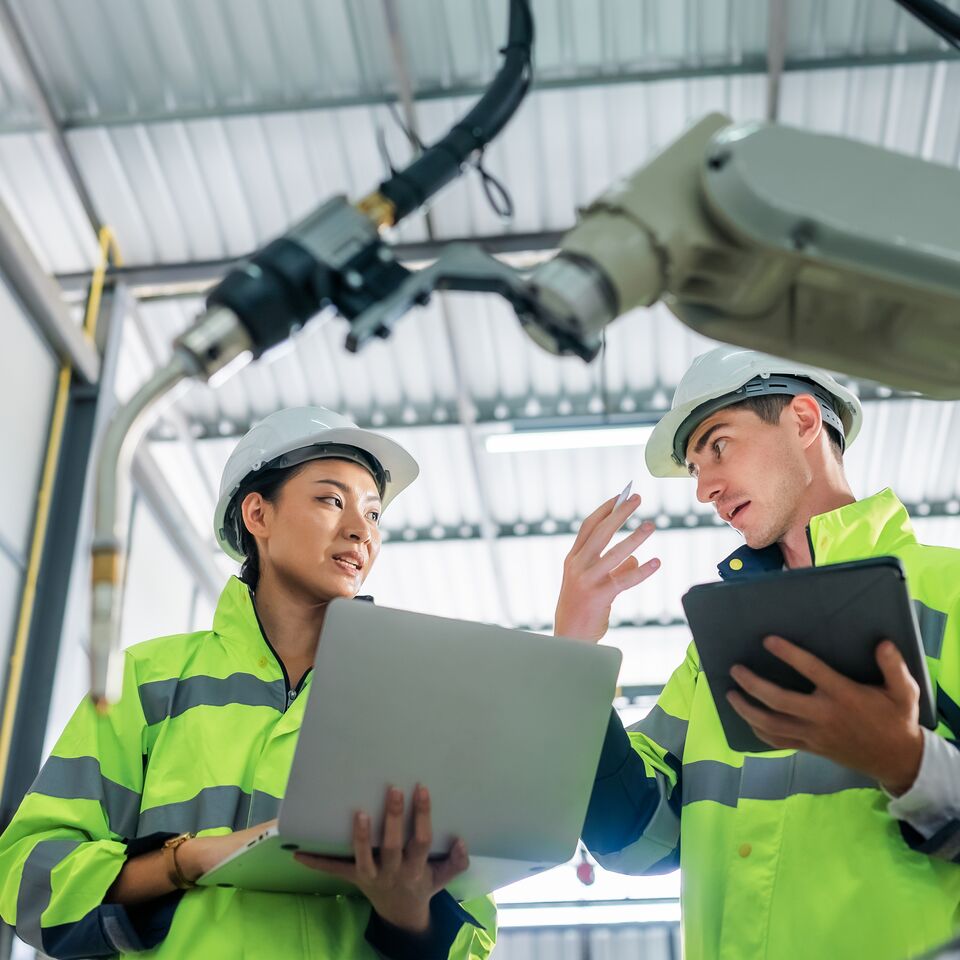 COLOUR-IMAGE_two-workers-wearing-hi-vis-coats-holding-devices_apr26