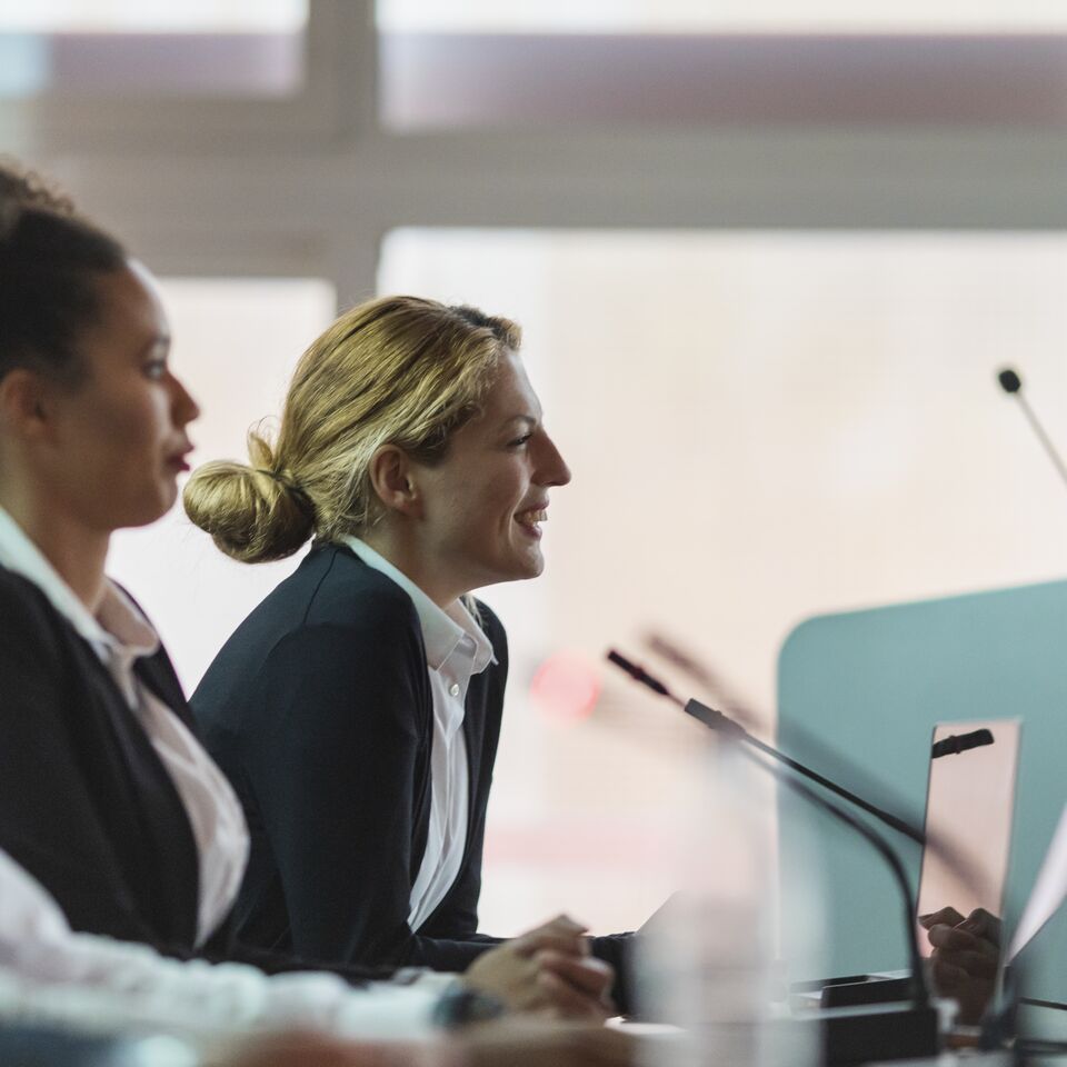 COLOUR-IMAGE_woman-smiling-in-a-government-setting-meeting_feb26