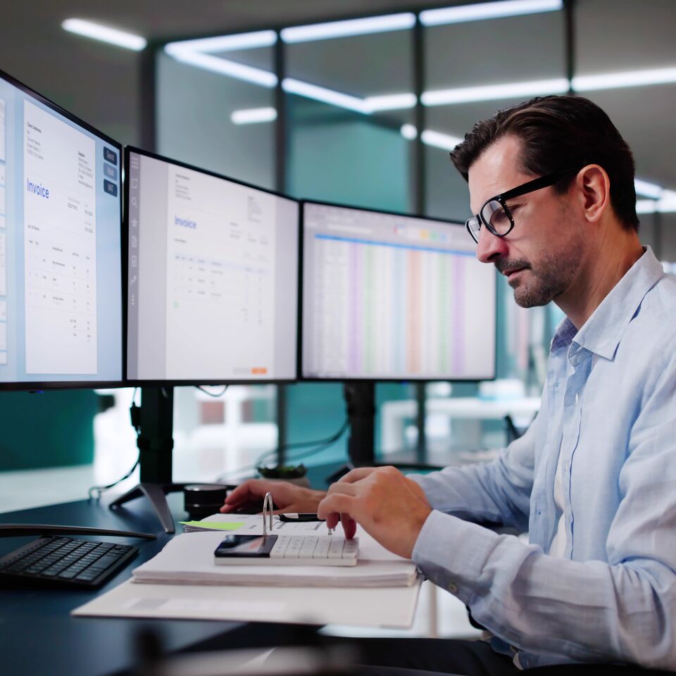 COLOUR-IMAGE_man-in-office-working-monitors_feb26