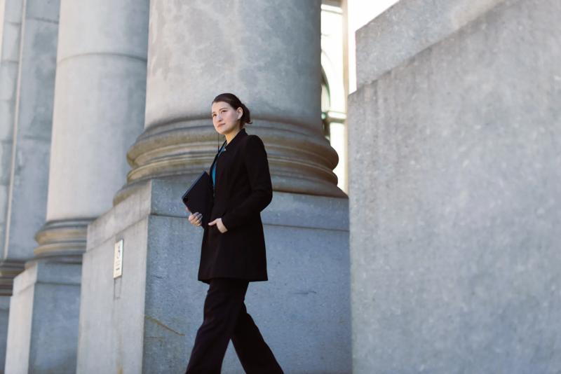 COLOUR-IMAGE_woman-walking-out-of-government-building_feb26