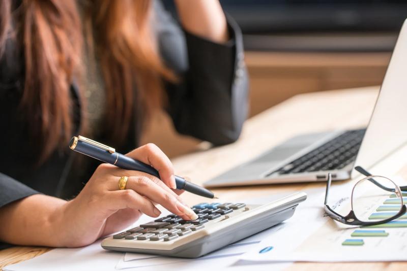 COLOUR-IMAGE_woman-holding-pen-with-calculator_feb26