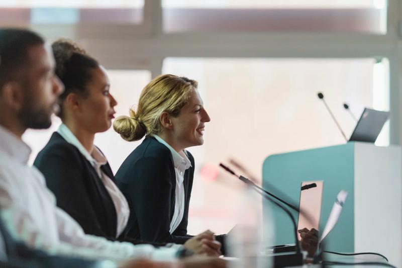 COLOUR-IMAGE_woman-smiling-in-a-government-setting-meeting_feb26