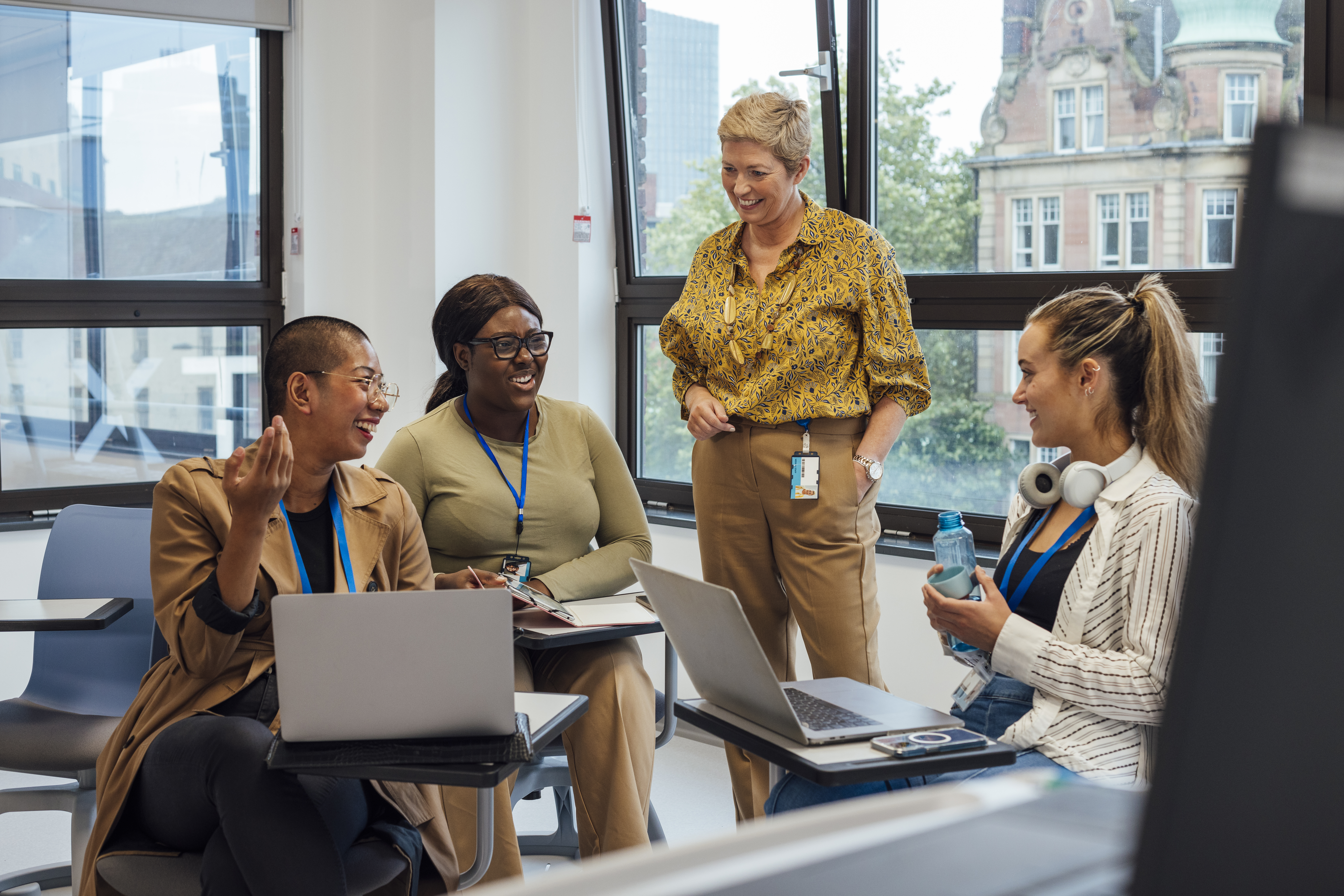 COLOUR-IMAGE_female-teacher-discussing-with-three-students_apr26