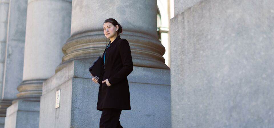 COLOUR-IMAGE_woman-walking-out-of-government-building_feb26
