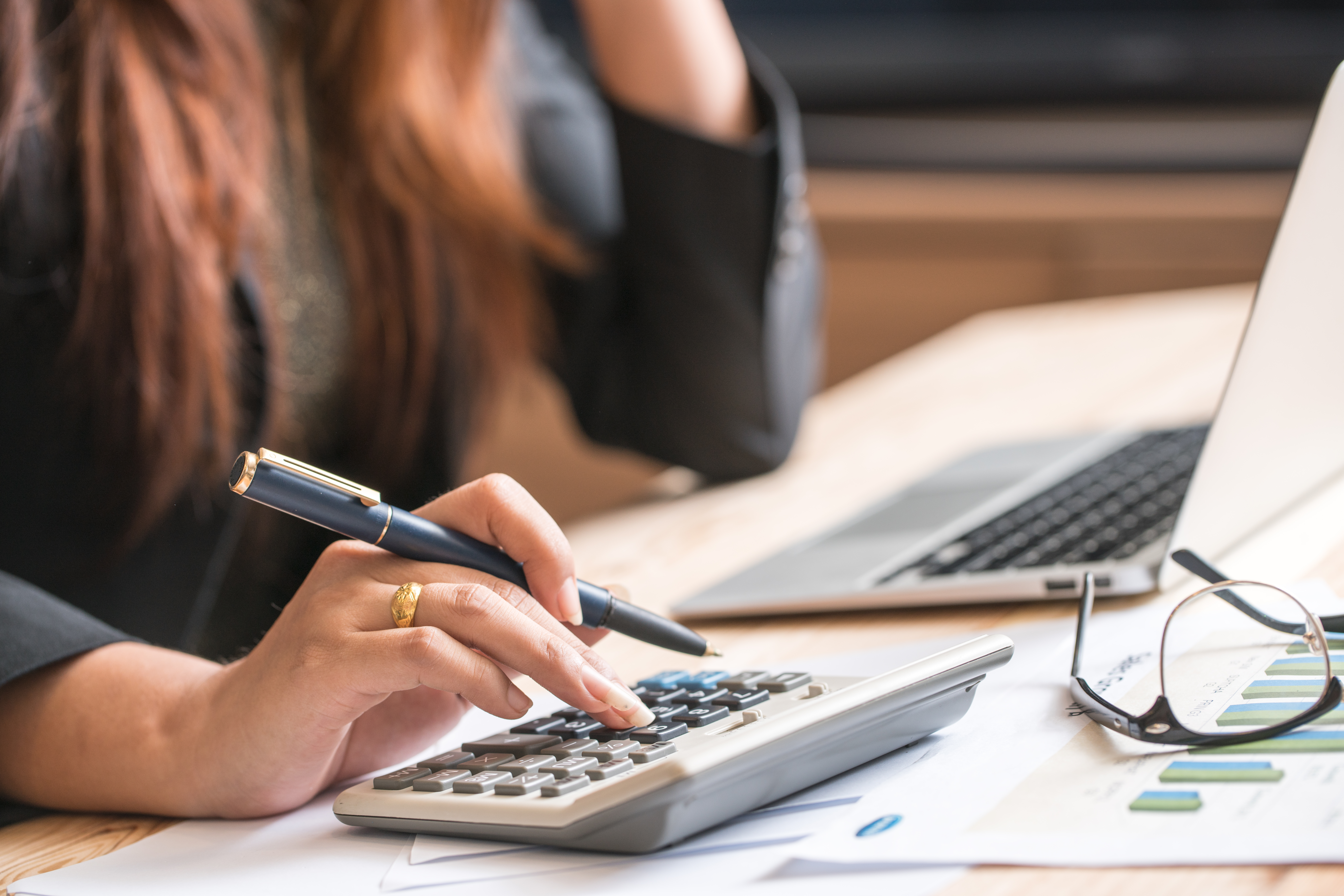 COLOUR-IMAGE_woman-holding-pen-with-calculator_feb26